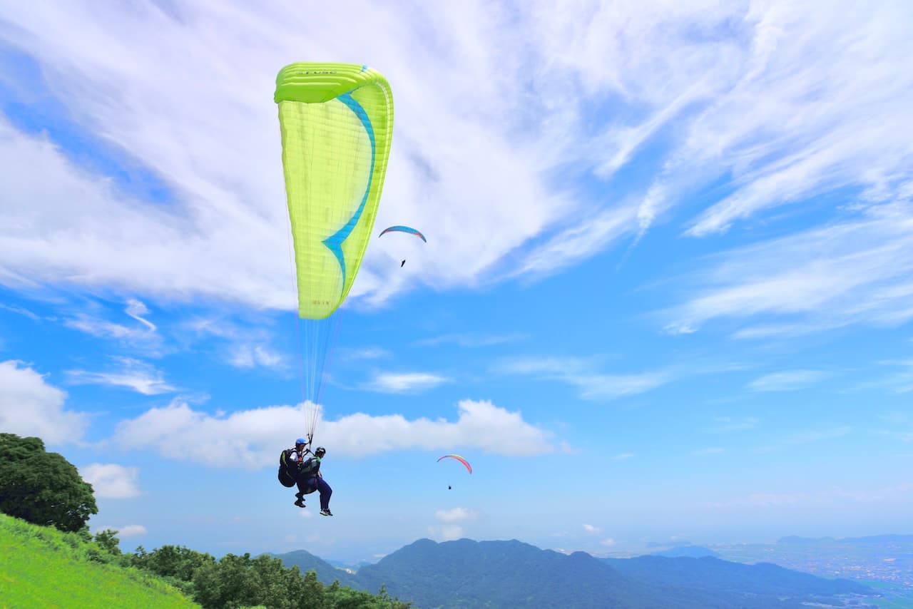 平尾台の空を飛ぶ二人乗りのパラグライダー